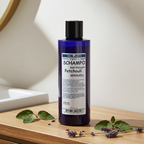 Plastflaska med 250 ml MacUrth Patchouli Schampo placerad på träyta med patchouliblad