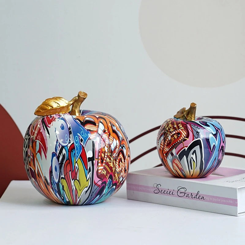 Detaljbild av färgstarkt graffiti-äpple i resin på bord.